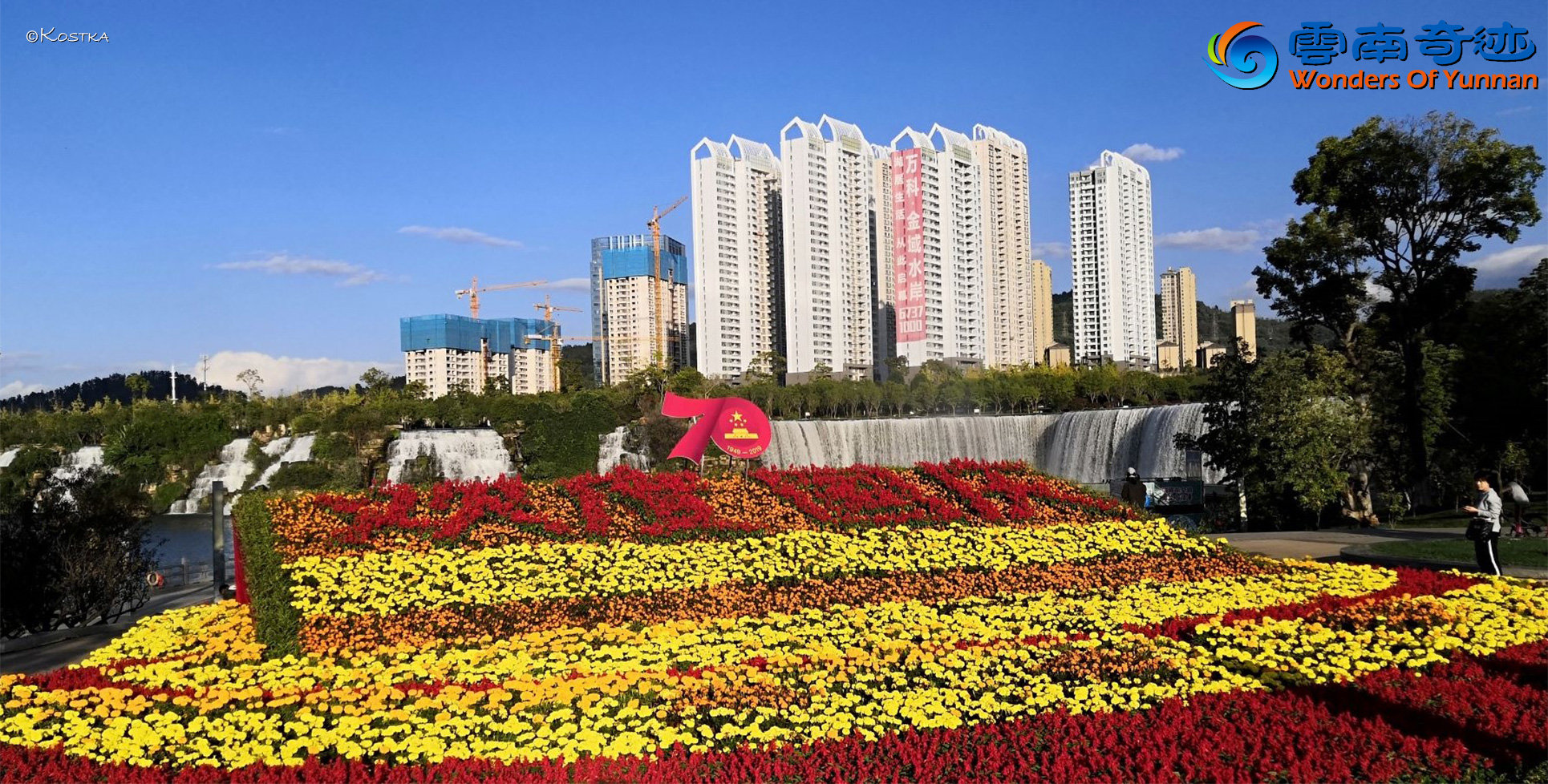 Flowerbed with beautiful yellow and red flowers on the upper platform in front of the waterfall for the 70 anniversary of China at the main entrance to the Park at the south-west