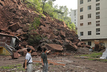 two men looking at landslide and rocks slide in yunnan country side china